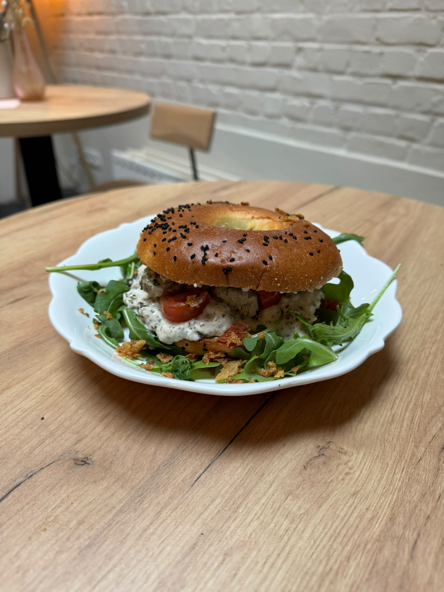 Een belegde bun met verse groenten op een bord bij Spoons